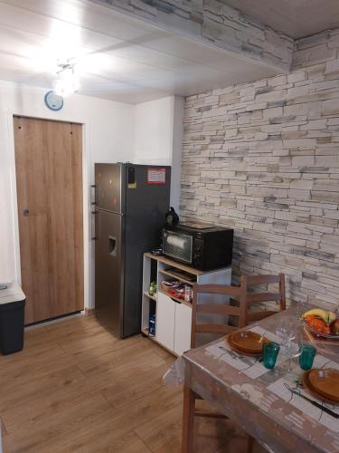 kuchnia ze stalową lodówką i stołem w obiekcie Appartement comme à la maison w mieście Bourbonne-les-Bains