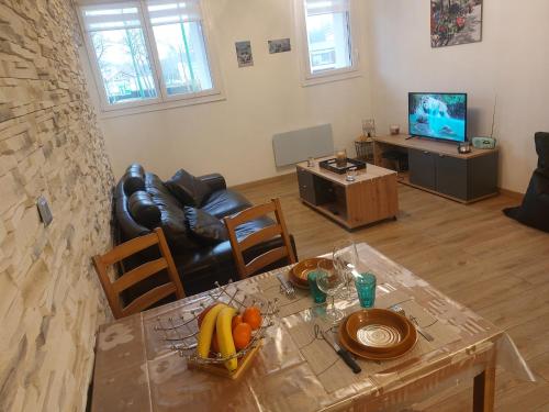 salon ze stołem i owocami w obiekcie Appartement comme à la maison w mieście Bourbonne-les-Bains