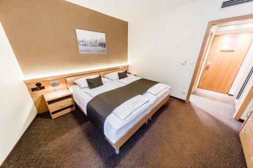 um quarto de hotel com uma cama grande e uma janela em Archibald City em Praga