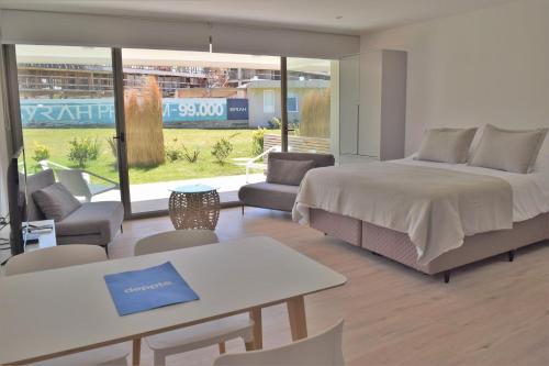 a bedroom with a bed and a table and chairs at SYRAH Premium B1 - Vistas al Parque by depptö in Punta del Este