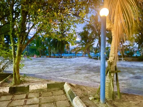 a street light next to a beach with trees at Homestay Legacy Kamariah Ahmad,Lumut in Lumut