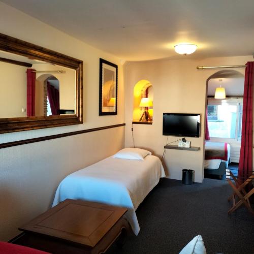 a hotel room with a bed and a television at Logis HOTEL RESTAURANT La Régence in Cherbourg en Cotentin