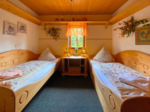 a room with two beds and a window at RATAGS Kunsthandwerkerhaus in Langenwolmsdorf