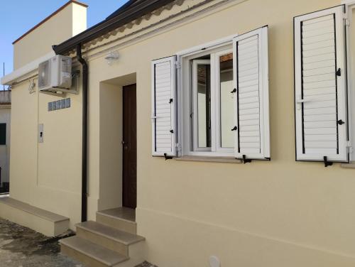 una casa con due finestre e una porta di Namastè a Gasponi