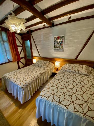 two beds sitting in a room with wooden floors at Casa Magnolia in Cumbayá