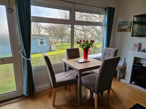 a dining room with a table and chairs and a window at Caldon Holiday Chalet sleeps 4 in Dartmouth WIFI Electric inc Pet friendly in Dartmouth