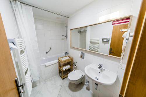 a bathroom with a sink and a toilet and a mirror at Archibald City in Prague