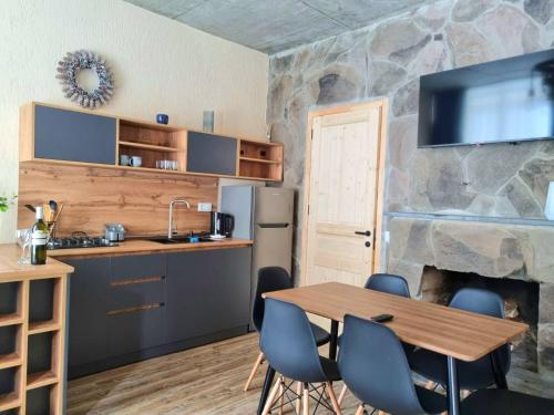 eine Küche und ein Esszimmer mit einem Tisch und einem Kamin in der Unterkunft Greenfield Bakuriani in Bakuriani