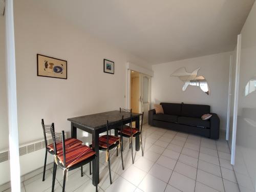un salon avec une table, des chaises et un canapé dans l'établissement Port FREJUS T2 39m2 climatise Belle terrasse Balcon, à Fréjus
