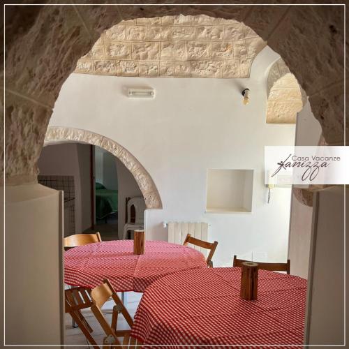 una sala da pranzo con tavolo e tovaglia rossa di Trulli Casalini civico 27 ad Alberobello