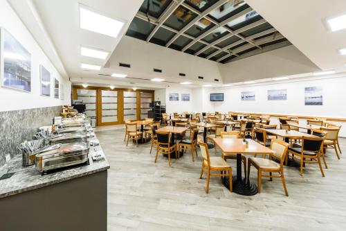 a restaurant with wooden tables and chairs in a room at Archibald City in Prague