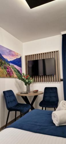 a bedroom with two chairs and a table and a tv at M apartmani in Lukavica