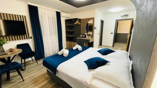 a bedroom with a large bed with blue pillows at M apartmani in Lukavica