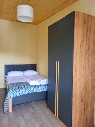 a bedroom with a bed and a large cabinet at Greenfield Bakuriani in Bakuriani