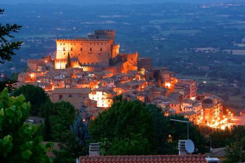 een uitzicht op een stad in de nacht met een kasteel bij Casetta papacqua in Soriano nel Cimino