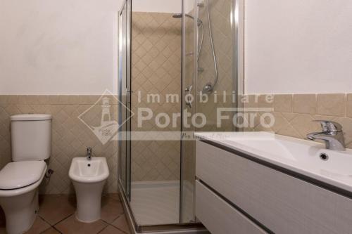 帕勞的住宿－L325 - Bilocale con giardino e vista mare panoramica a Porto Mannu，浴室配有卫生间、盥洗盆和淋浴。