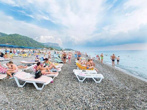 a group of people sitting on a beach at MIRAMOR HOTEL & Spa - ULTRA ALL INCLUSIVE SELECTION in Kemer