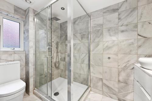 ein Bad mit einer Dusche und einem WC in der Unterkunft Hampstead Opulence Apartment - Luxurious Split Level Property in London