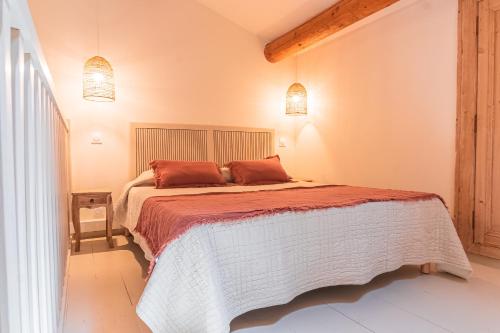 1 dormitorio con 1 cama y 2 luces colgantes en La Bastide des Pins en Castillon-du-Gard