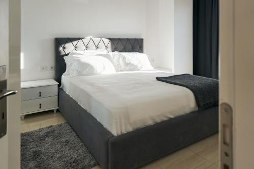 um quarto com uma cama grande e uma cabeceira preta em The Garrison Apartment em Saranda