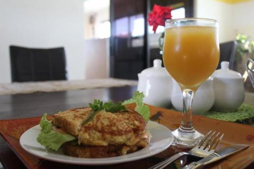 un piatto di cibo e un bicchiere di succo d'arancia di Apple Guesthouse a Lothlekane