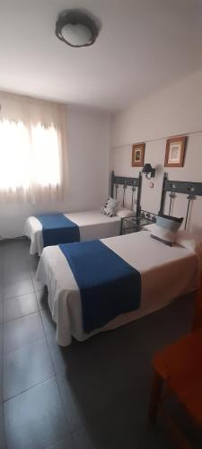 a room with two beds and a window at Hostal Casa Juan in Castejón de Sos