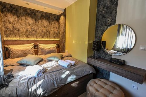 a bedroom with a large bed with a mirror at BANE APARTMANI 7 in Kraljevo