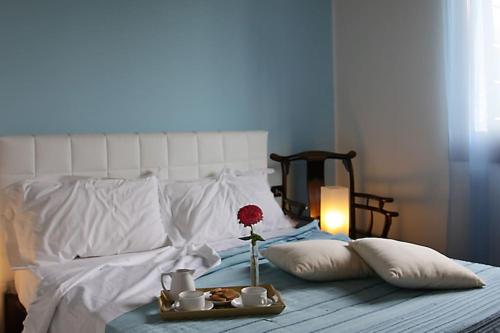 a bed with a tray of food and a flower on it at Agriturismo Ai Carpini in Marcon