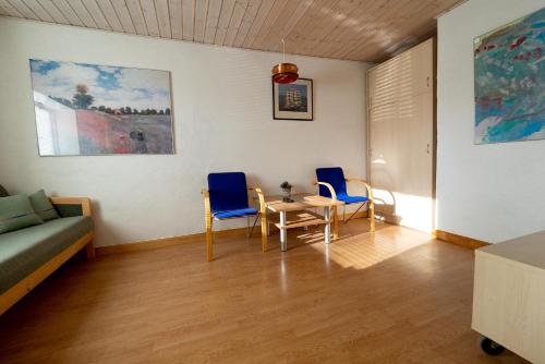 ein Wohnzimmer mit 2 Stühlen, einem Tisch und einem Sofa in der Unterkunft Understedvej 103 in Sæby