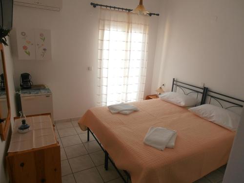 a bedroom with a bed with two towels on it at Glaros Rooms in Koufonisia