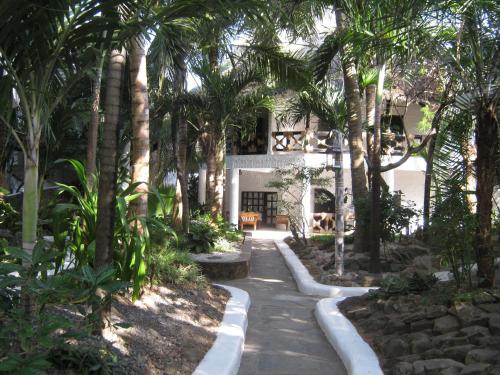a walkway in front of a house with palm trees at Scorpio Villas Resort in Malindi