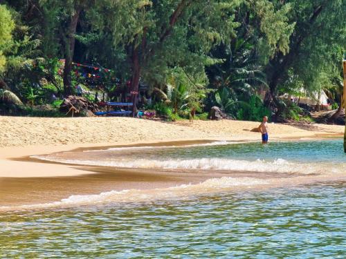 a person standing in the water at the beach at SunBoo Beach Bungalows in Koh Rong Sanloem