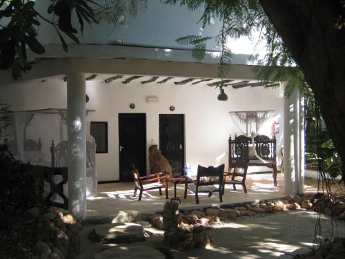 a patio with chairs and a table and a fireplace at Scorpio Villas Resort in Malindi