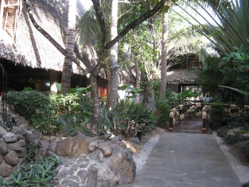 a garden with palm trees and a walkway at Scorpio Villas Resort in Malindi