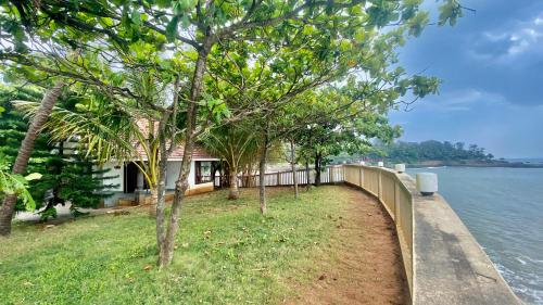 a house with a fence next to the water at Willo stays The Metro Landsend Beach Resorts in Kannur