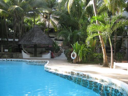 a resort swimming pool with a gazebo and palm trees at Scorpio Villas Resort in Malindi