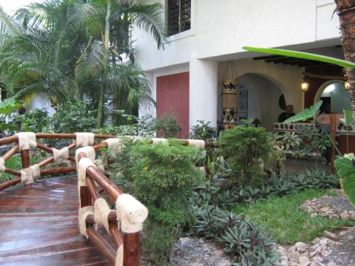 a house with a wooden fence and some plants at Scorpio Villas Resort in Malindi