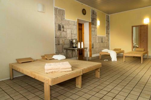 a room with two wooden benches in a room at Hotel San Giusto in Falcade