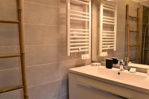 a bathroom with a sink and a mirror at Calm house, swimming pool and garden in Bénesse-Maremne