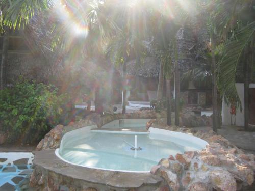 a hot tub in a resort with palm trees at Scorpio Villas Resort in Malindi