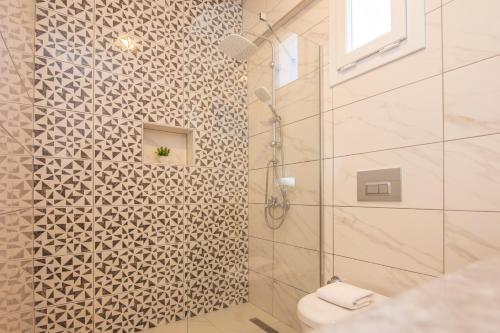 a bathroom with a shower with a toilet at SunTeos Villa Suites in Fethiye