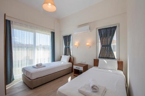 a hotel room with two beds and a window at SunTeos Villa Suites in Fethiye