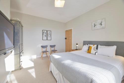 a bedroom with a large bed and a flat screen tv at Host & Stay - The Cottage in Corbridge in Corbridge