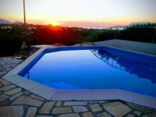 a swimming pool with a sunset in the background at Sardegna casa a 250 metri dal mare con piscina in Olbia