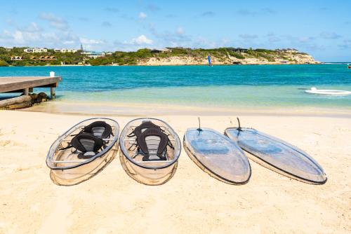threeogie boards sitting on the beach next to the ocean at Hammock Cove Antigua - All Inclusive - Adults Only in Willikies