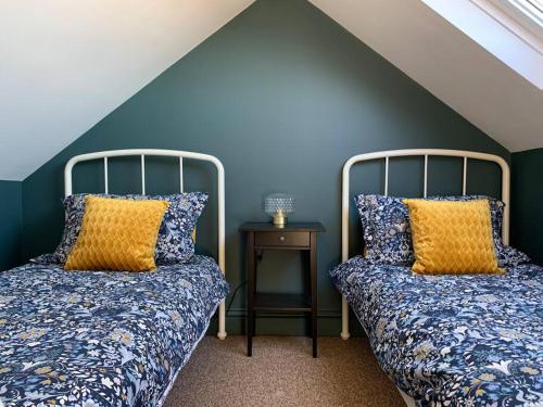 Duas camas num quarto com paredes azuis em No 11, Fishguard, Ideal for beach, coastal path and town! em Fishguard