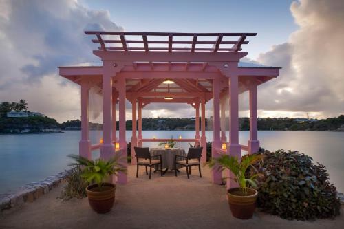 a gazebo with a table and chairs next to the water at Hammock Cove Antigua - All Inclusive - Adults Only in Willikies
