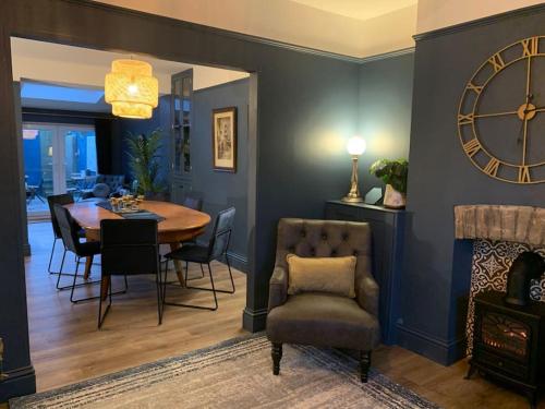 a dining room with a table and a clock on the wall at No 11, Fishguard, Ideal for beach, coastal path and town! in Fishguard