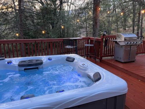 a hot tub on a deck with a grill at Peaceful Oak Haven Cabin near Yosemite in Mariposa