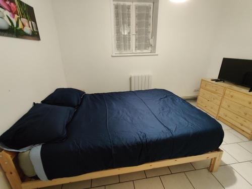 - un lit avec une couette bleue dans une chambre dans l'établissement Appartement calme au centre ville proche tribunaux, à Douai